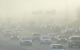 Cars at rush hour driving through thick smog