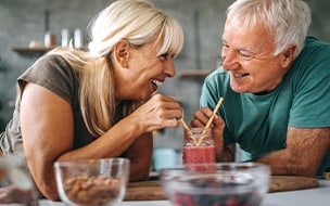 Loving senior couple drinking healthy smoothie in the kitchen at home